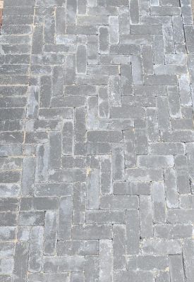 getrommelde betonklinkers antraciet in visgraatverband bestrating voor een oprit