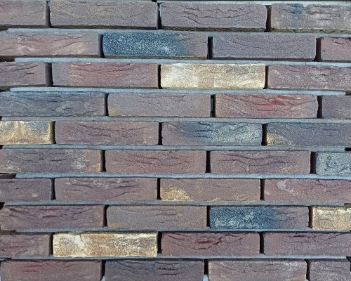 Metselsteen Aubergine bont geel gesinterd handvorm waalformaat.